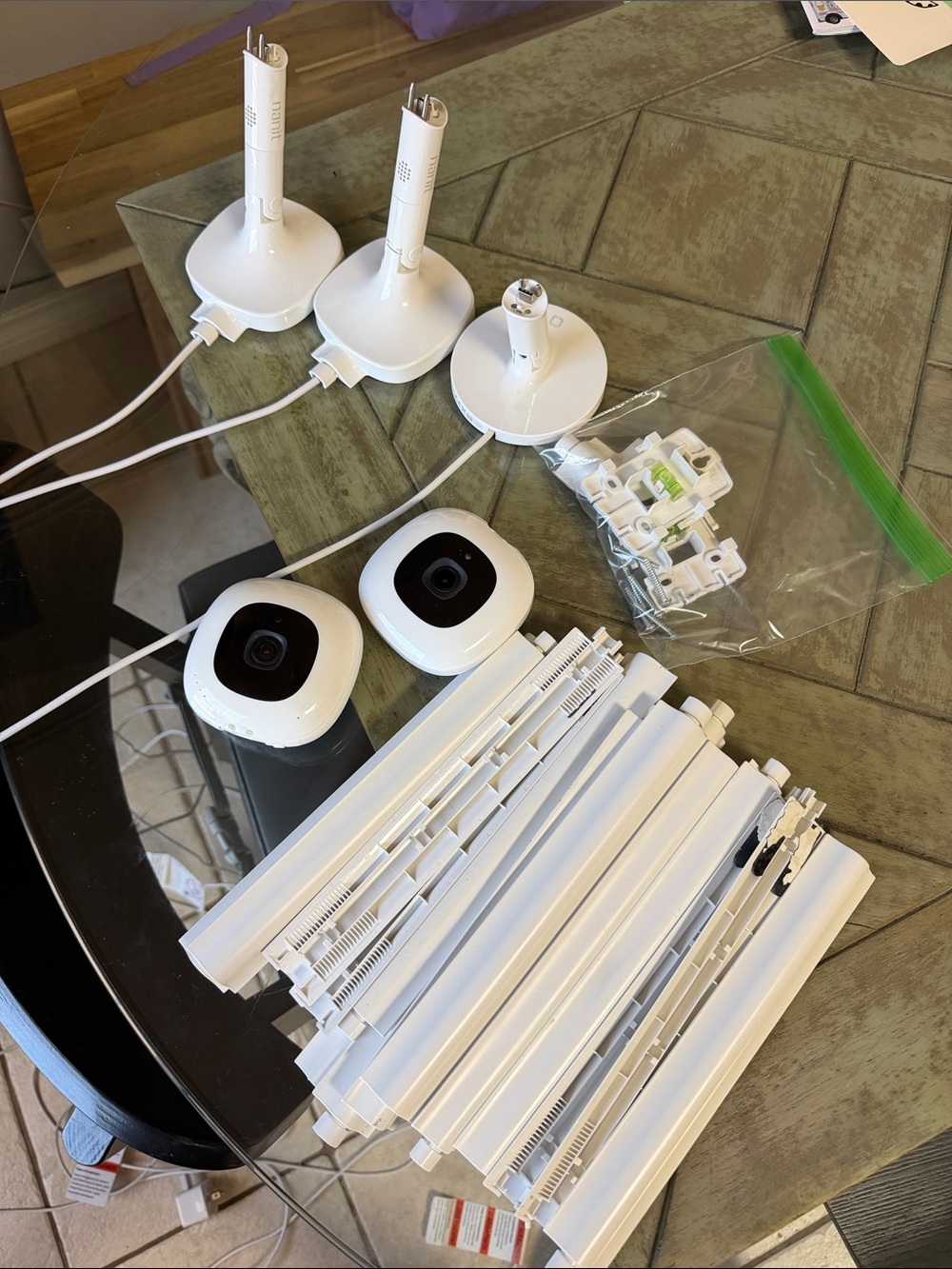 Two Nanit wall baby monitors with additional travel stand